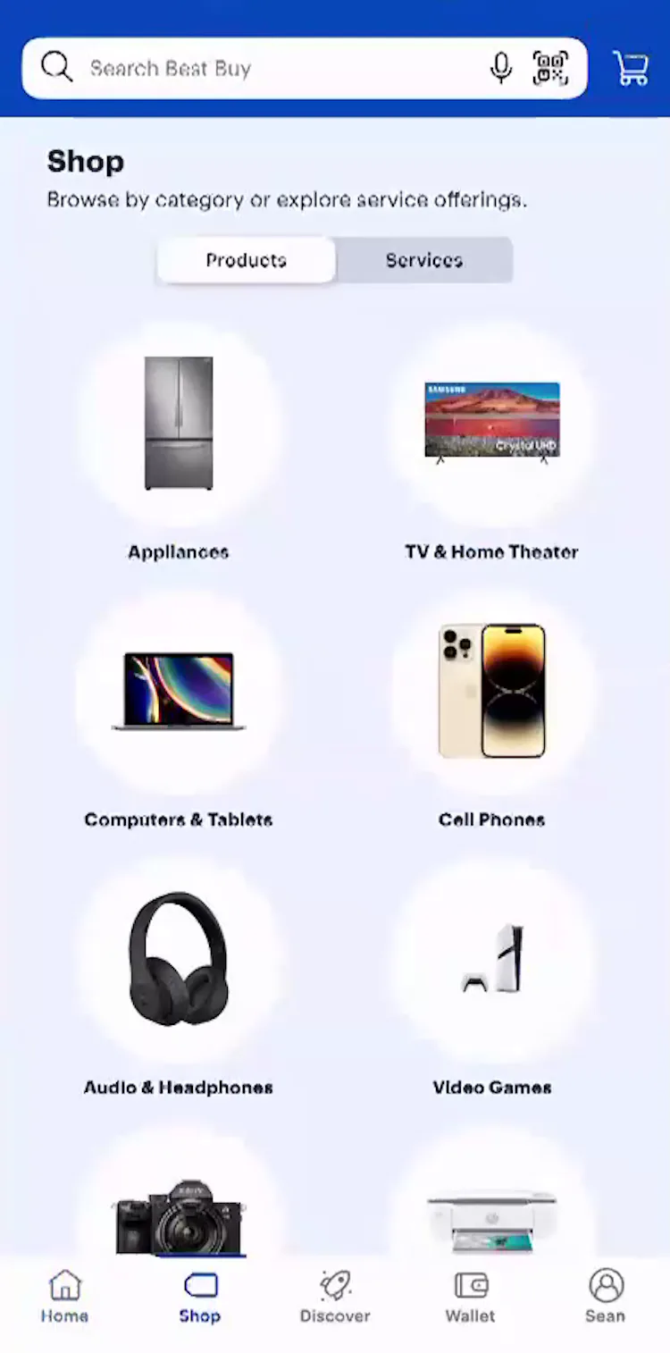 The “Shop” page on Best Buy mobile app with several category thumbnails visible.